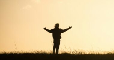 silhouette of person spreading hands