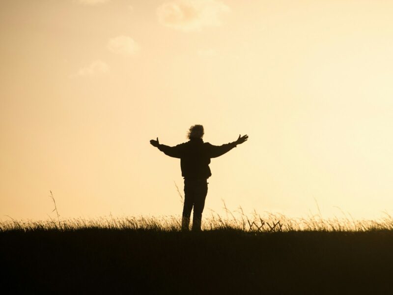 silhouette of person spreading hands